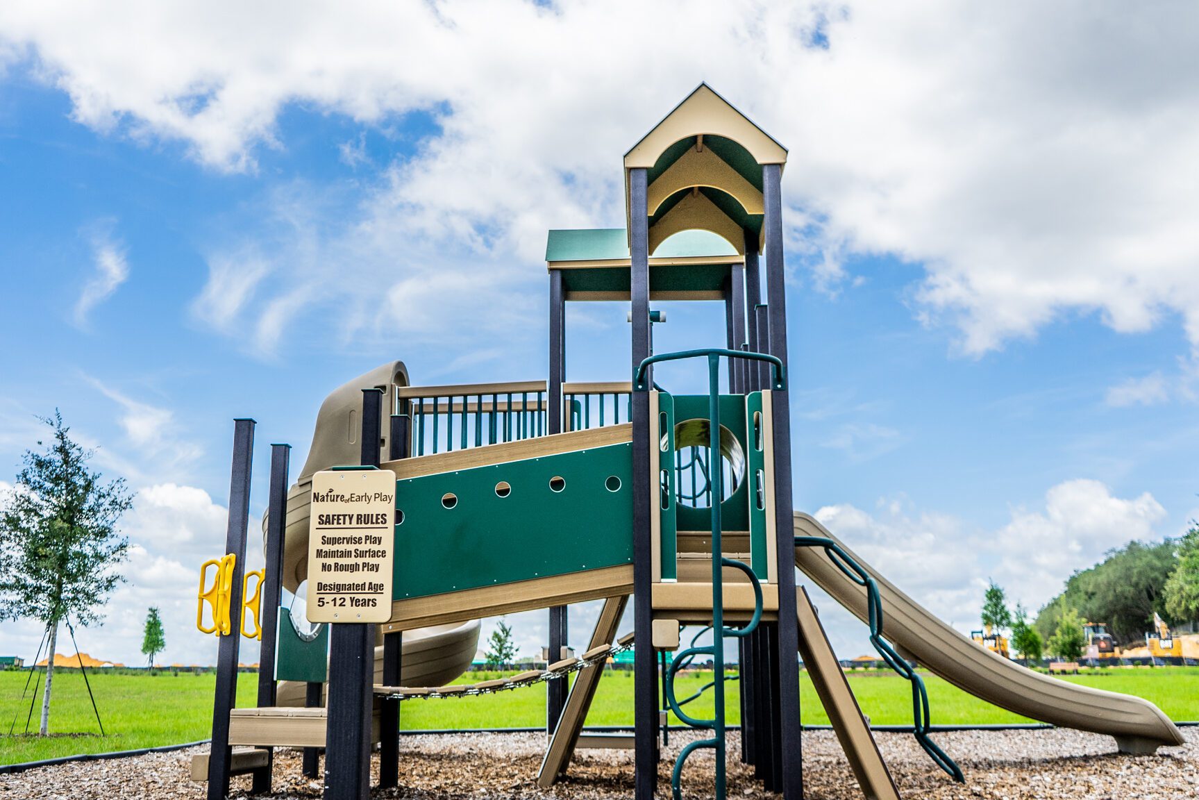 Green and beige play equipment in park