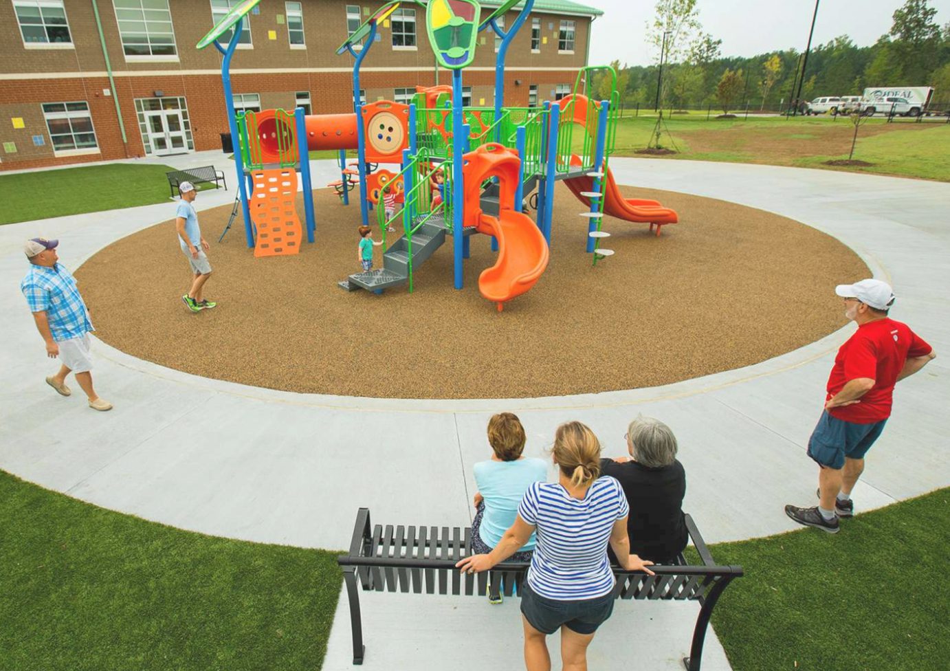 Adults watching kids at a playground