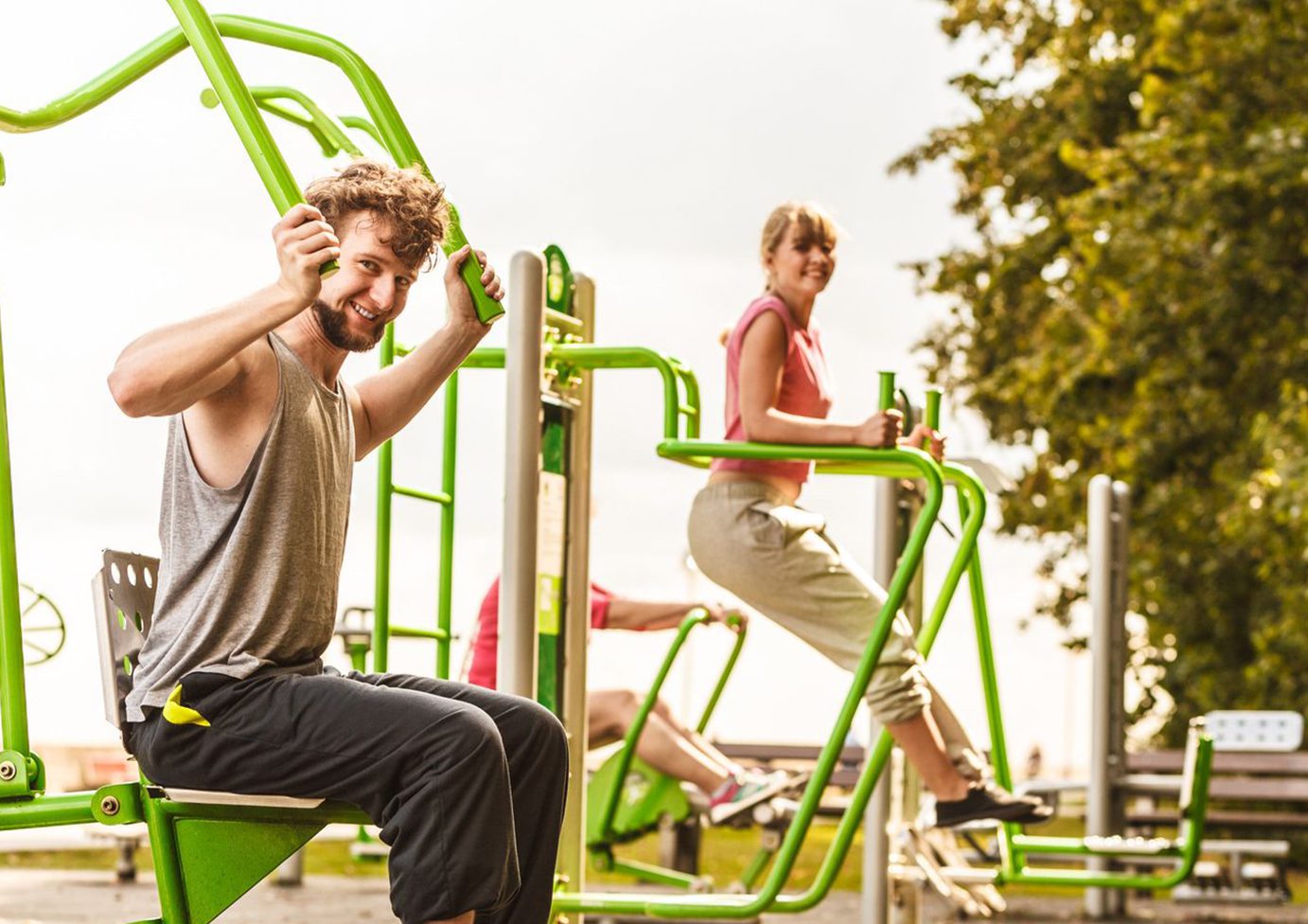 Group enjoying outdoor exercise machines