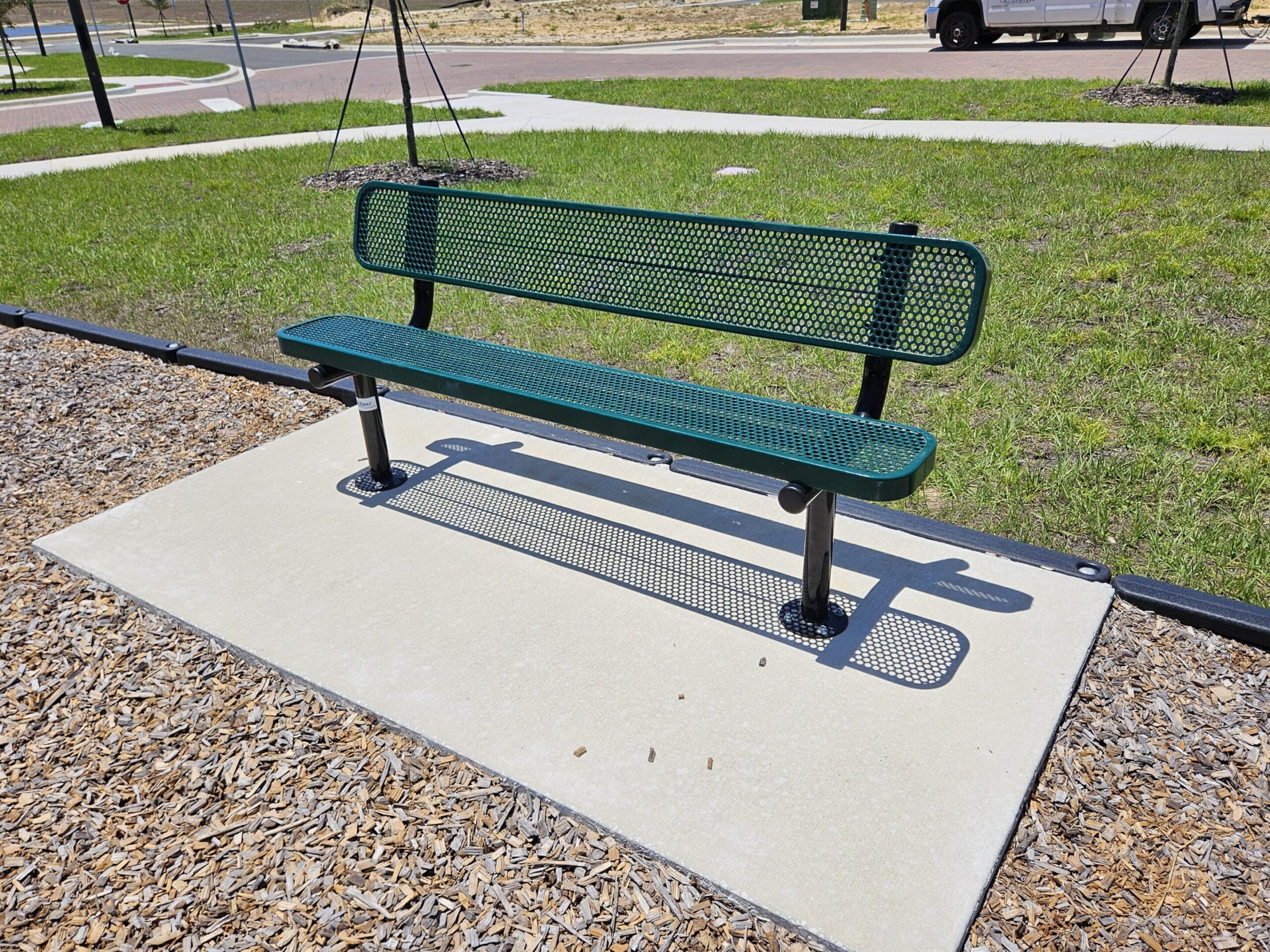 Metal bench casting shadow on ground