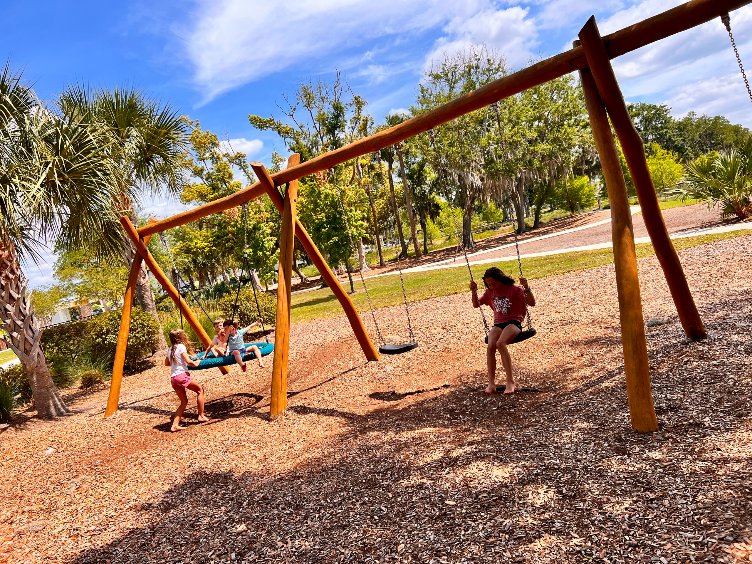 Kids swinging under a sunny sky