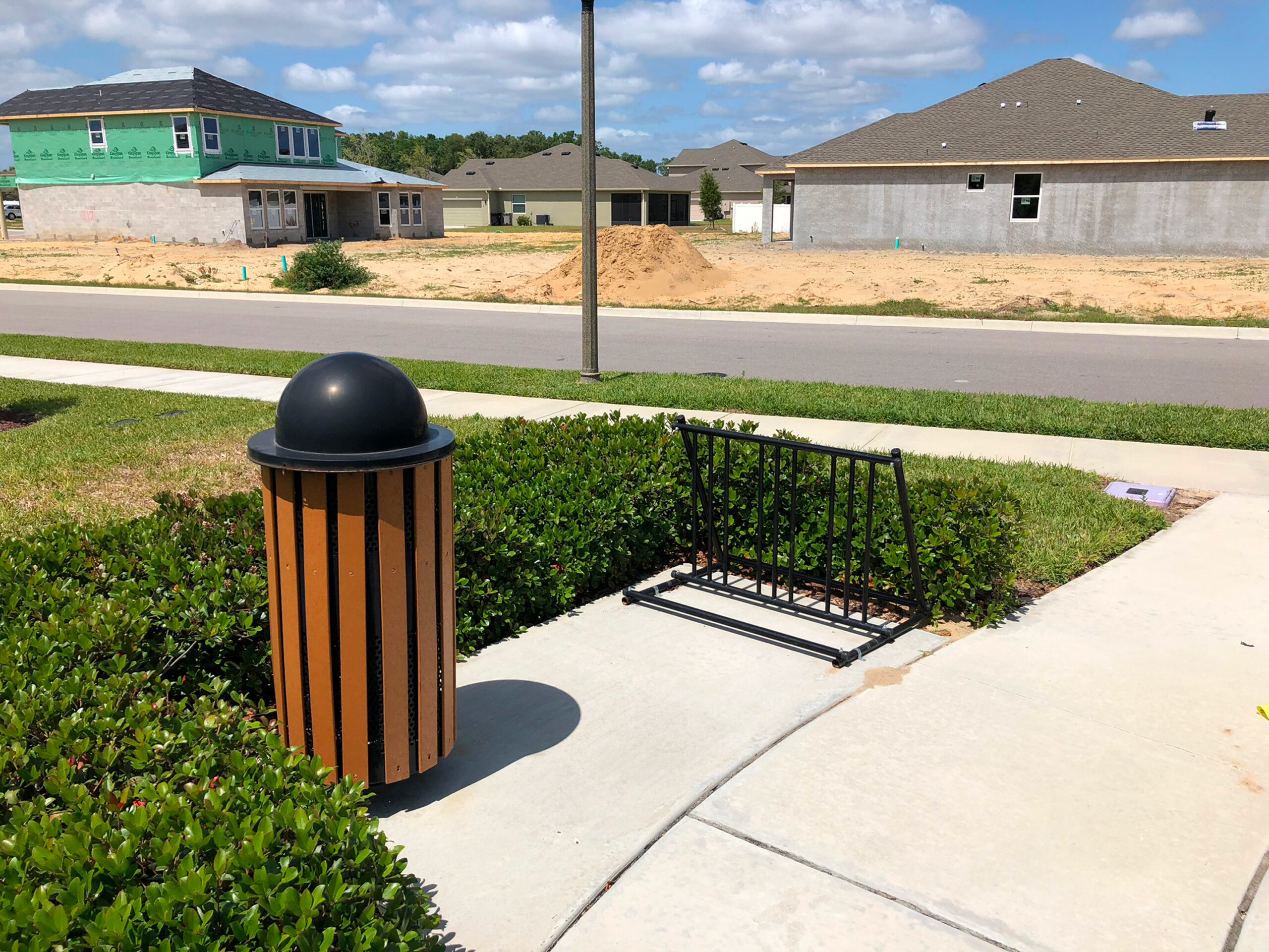 Trash can and bike rack by sidewalk