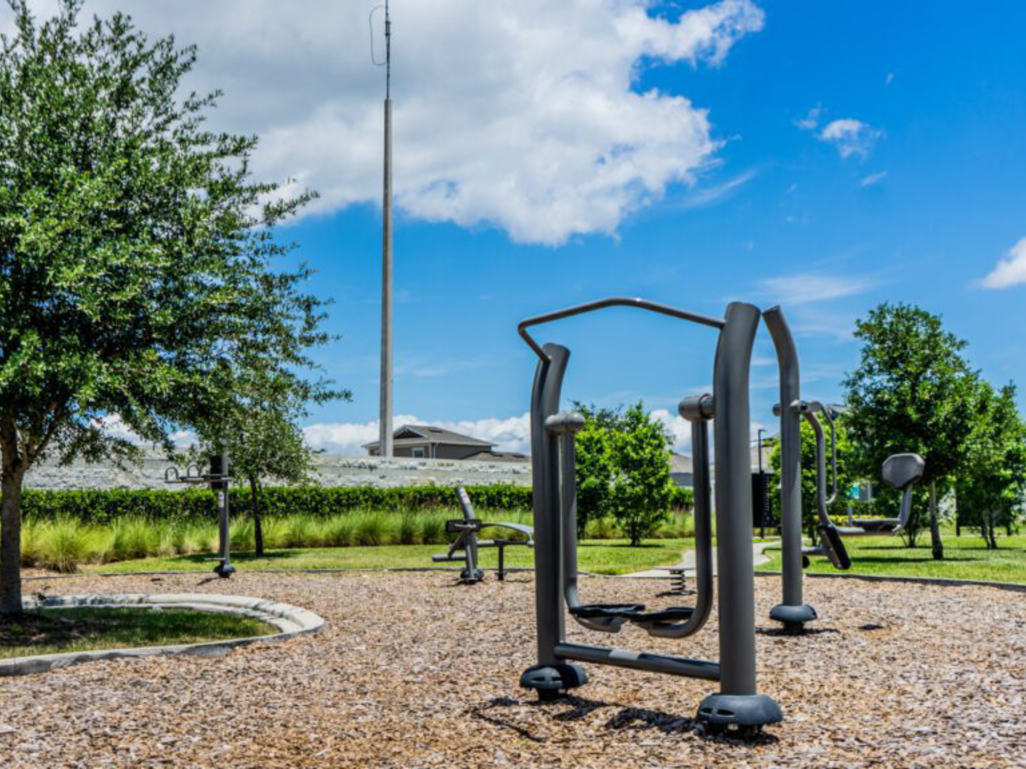 Outdoor gym equipment under a blue sky.